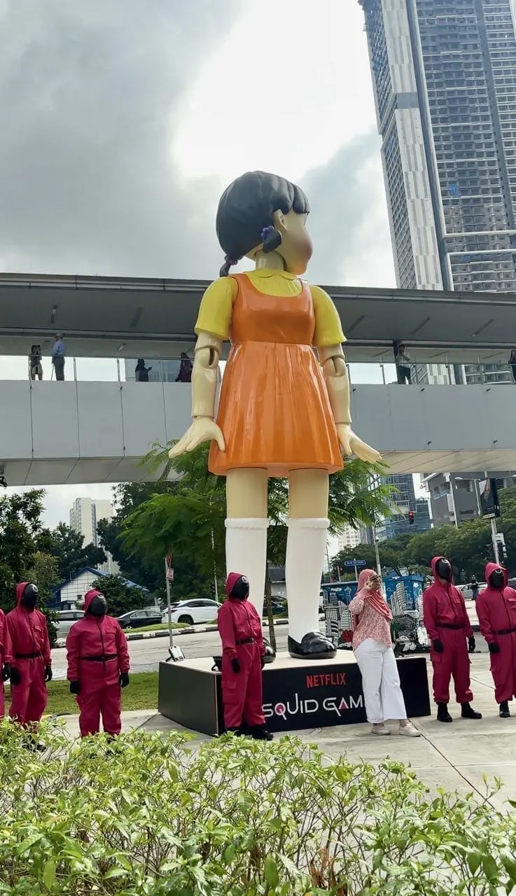 malaysian woman talking photo with huge Young-hee doll at mrt ampang park