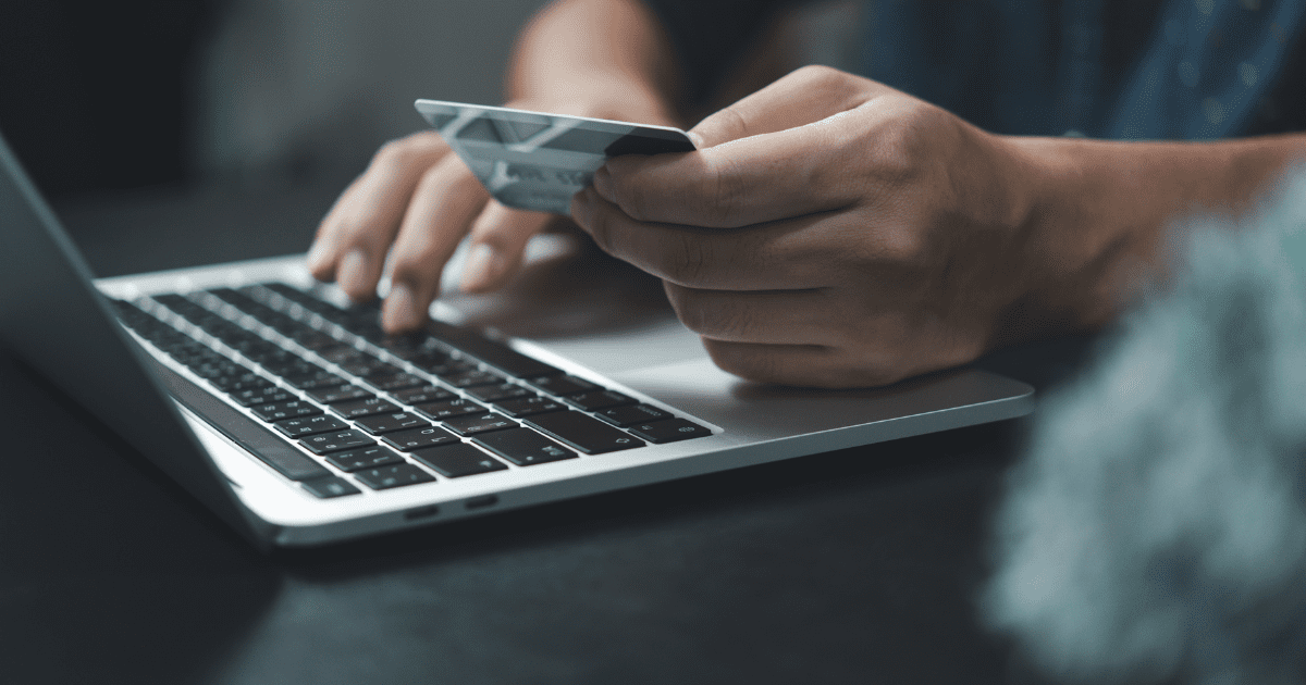man holding card while typing