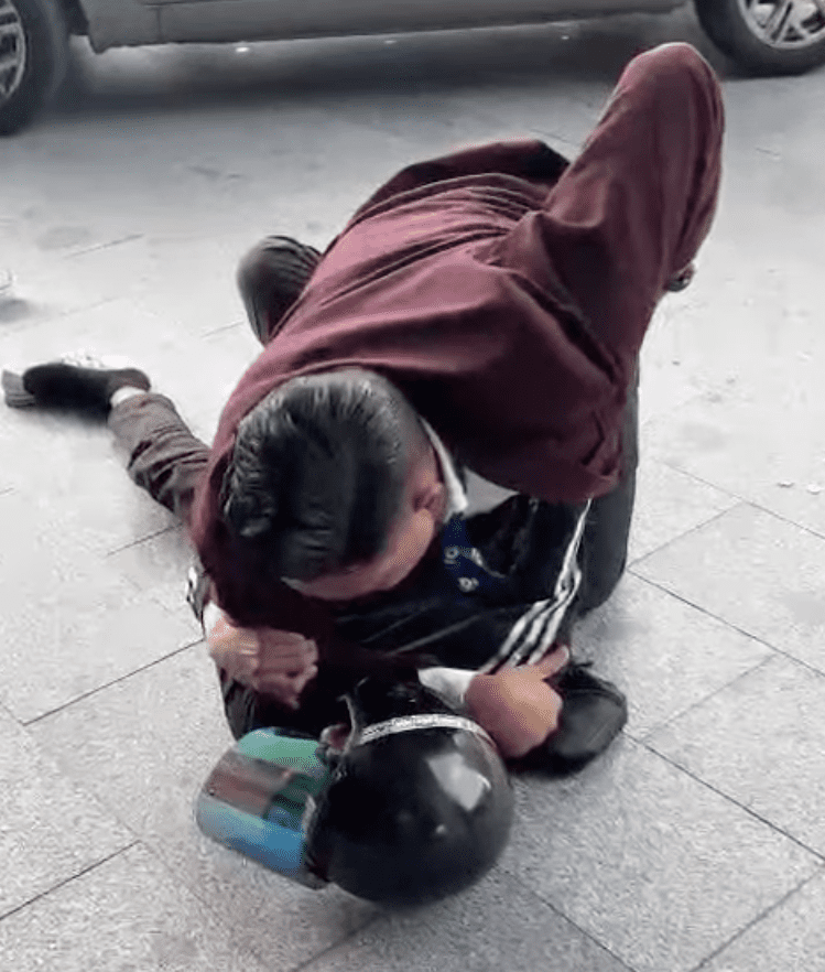 Man in red blazer chokehold delivery man at TRX