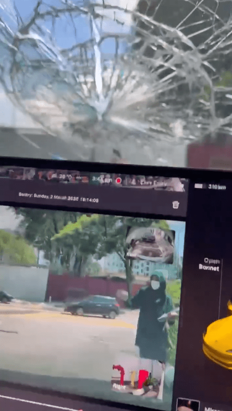 man is aiming to break the tesla's windscreen