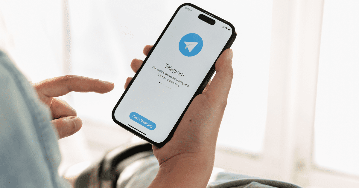 man is looking at telegram on his phone