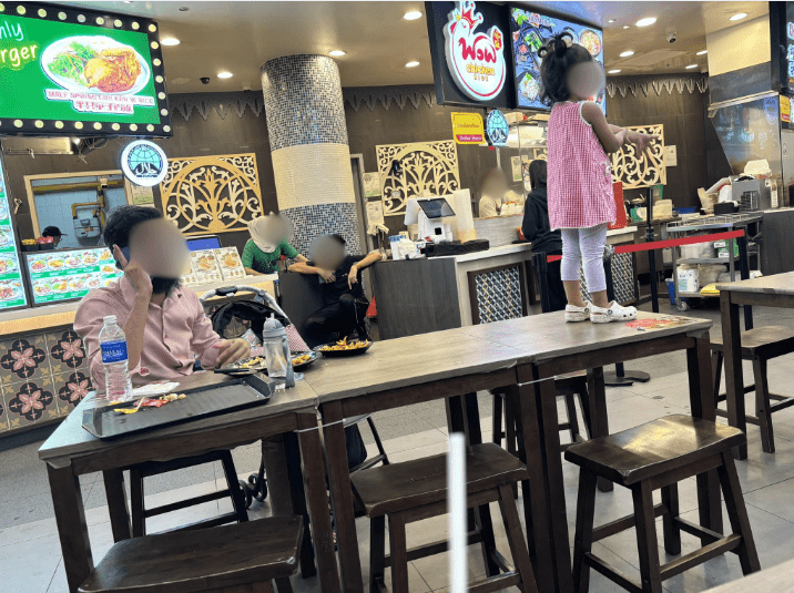 Man lets daughter stand on top of table