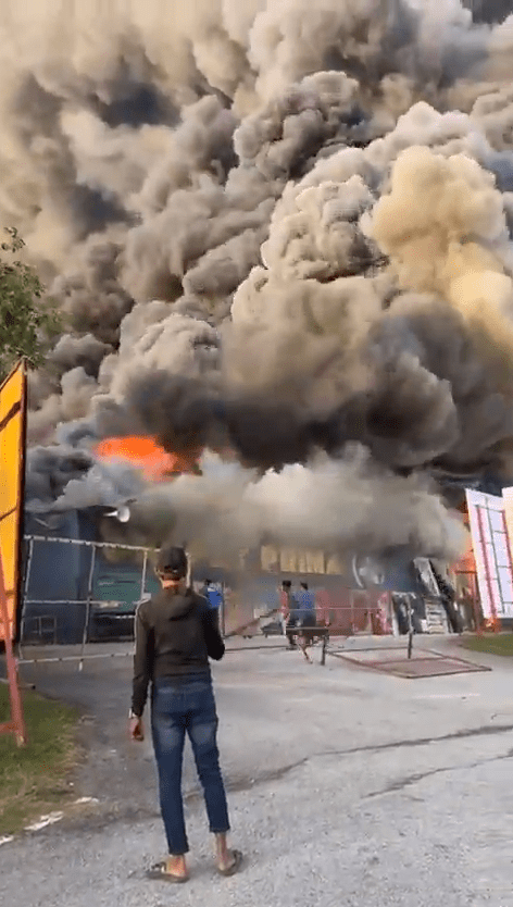 man looking at the fire at carpet factory in nilai 3