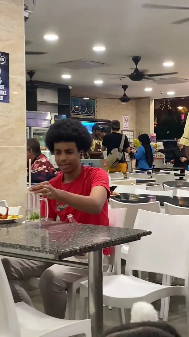 man putting back straw inside cup