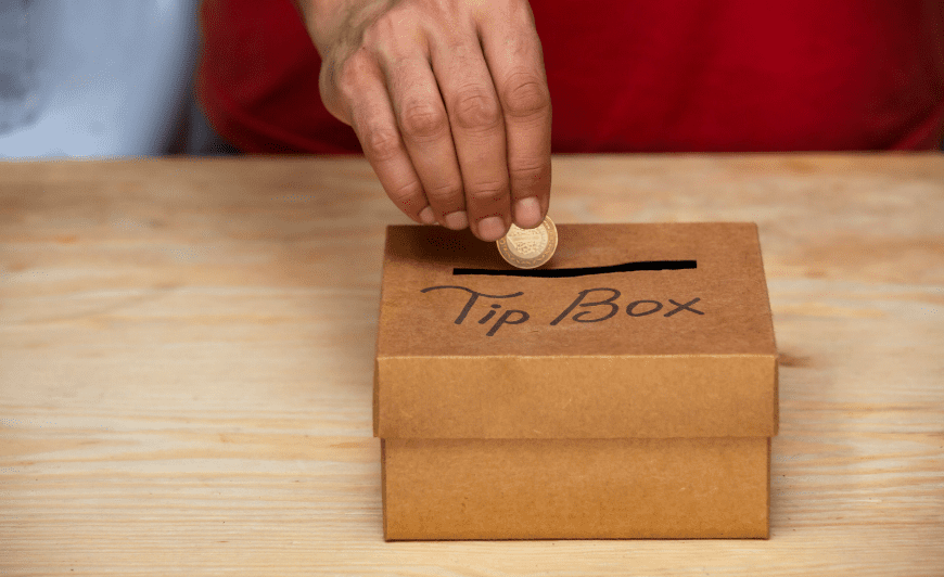 Man putting coin into tip box