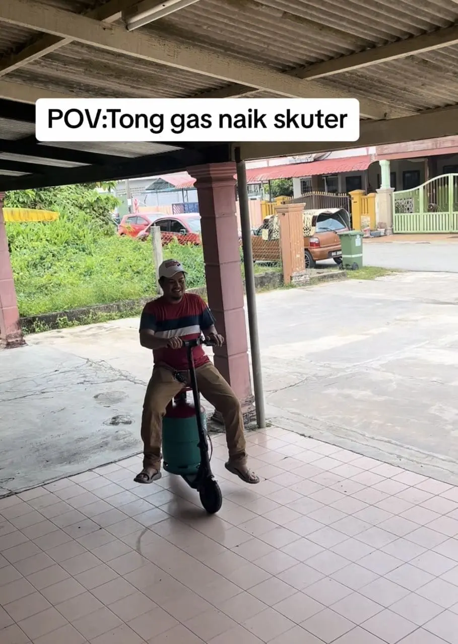 man riding e-scooter while sitting on top of gas cyclinders