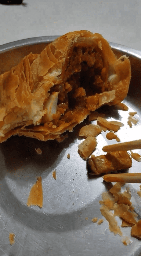 Man Showing Cigarette Butt Inside Curry Puff