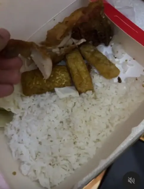 man showing half eaten chicken taht he received through ordering online