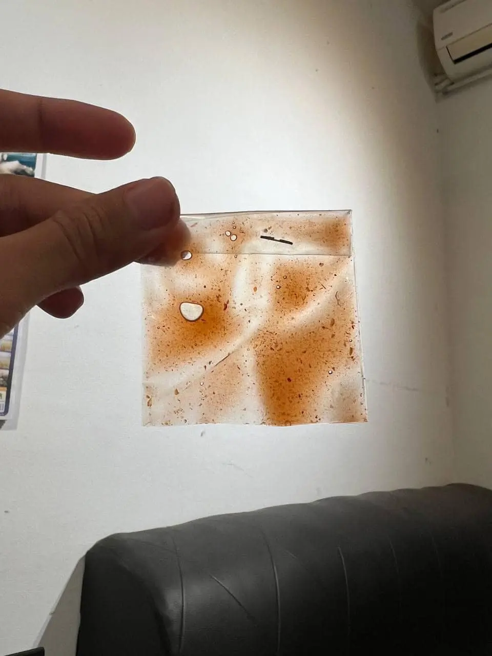 man showing one packet of chili sauce