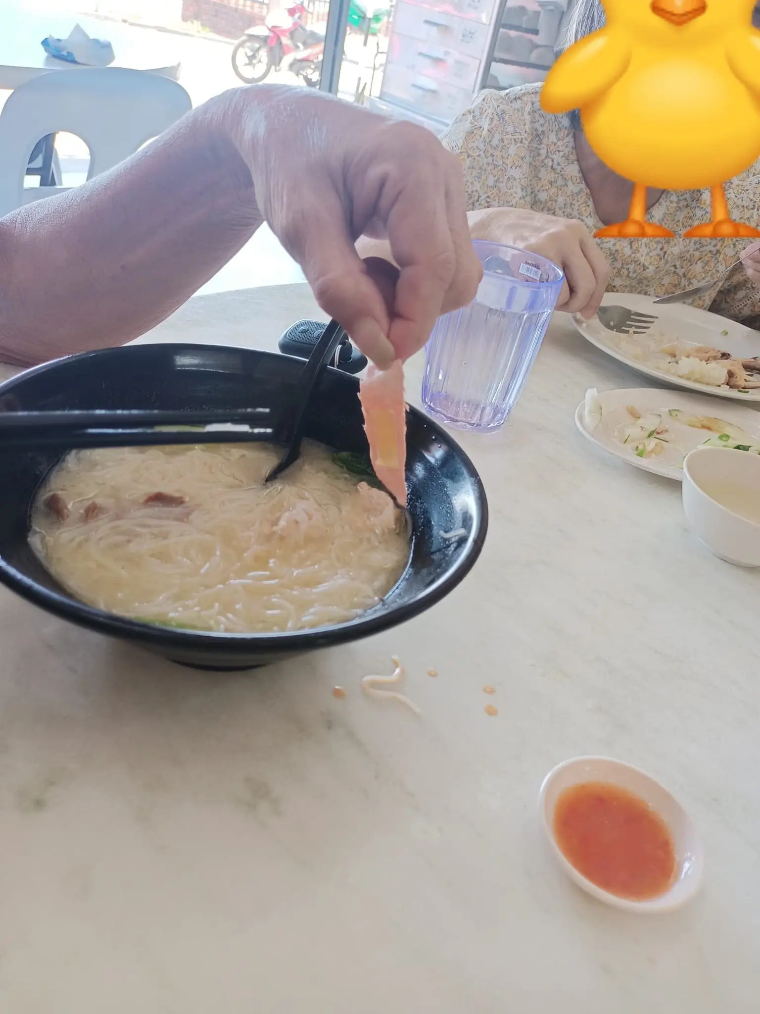 man showing plaster found inside noodle soup