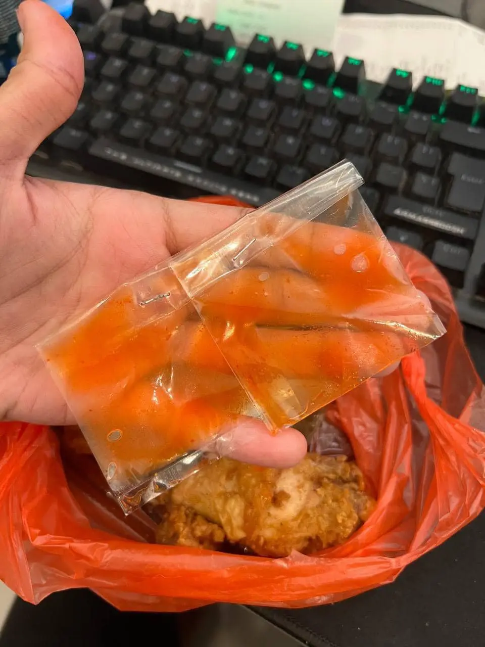 man showing two packet of chili sauce