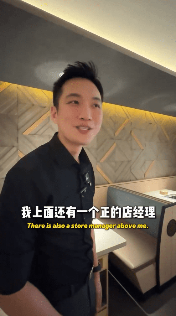 Man shows Xavier around his workplace at Haidilao