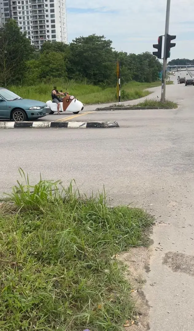 man sitting on the snoopy bike while waiting in the trafiic light