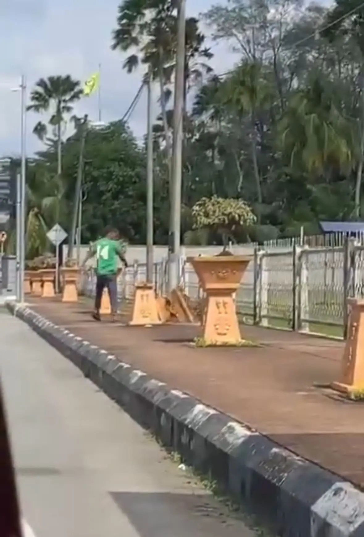 man smashes flower pots near police station
