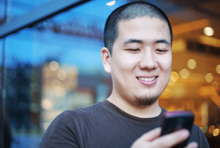 man smiling looking at his phone