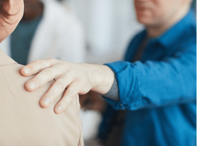 Man touching woman's shoulder