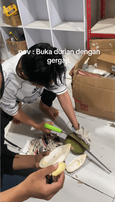 Man using a saw to open the durian