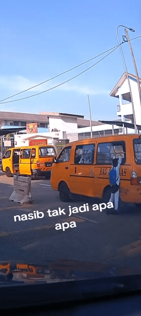 M'sian boy hangs onto bus window
