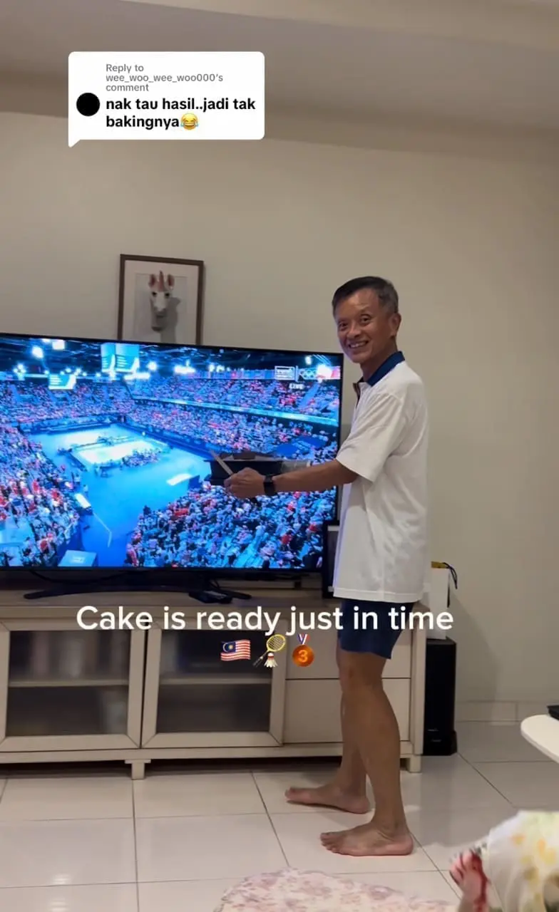 msian dad showing the cake infront of the tv