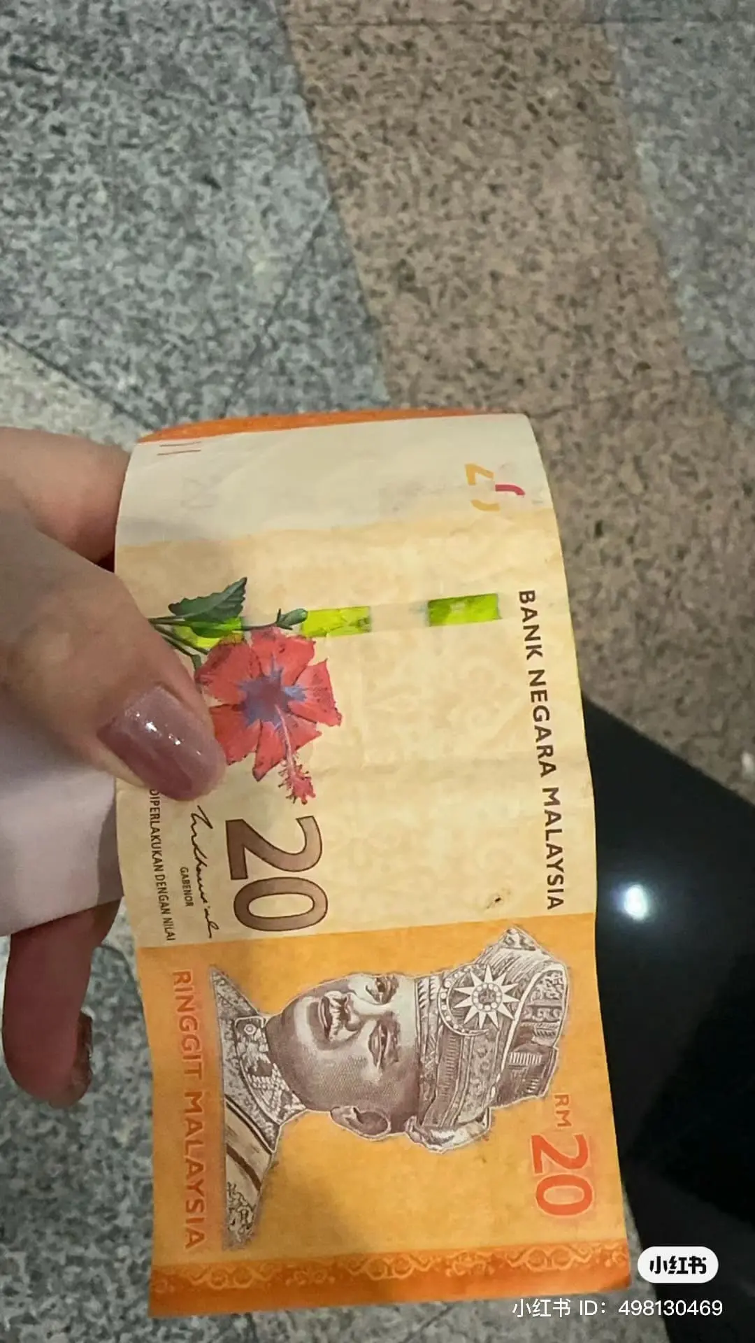 M'sian giving RM20 note to China tourist