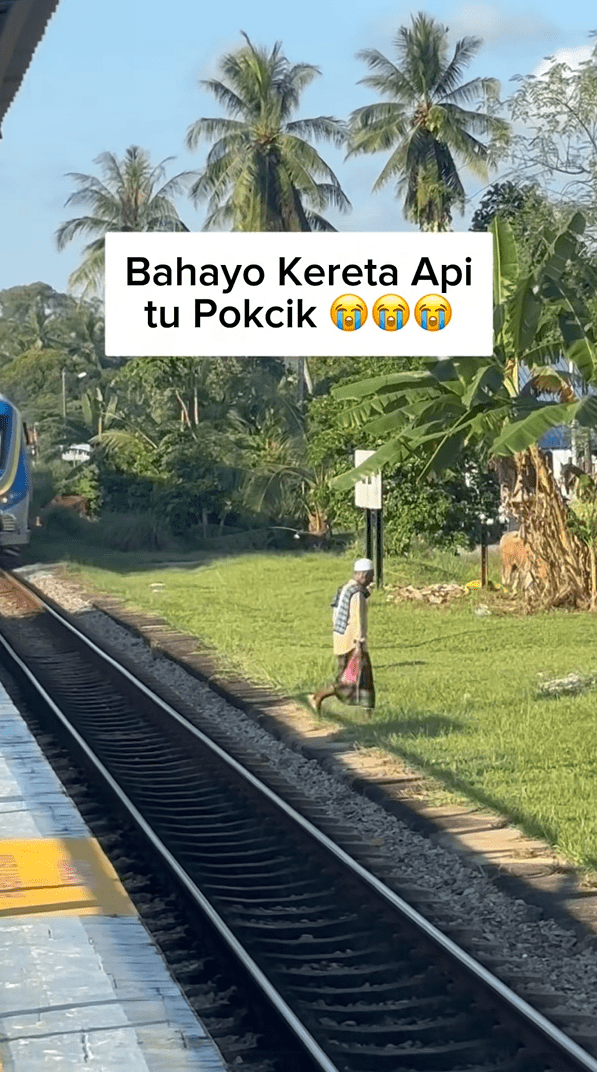 M'sian man crosses train tracks to the other side
