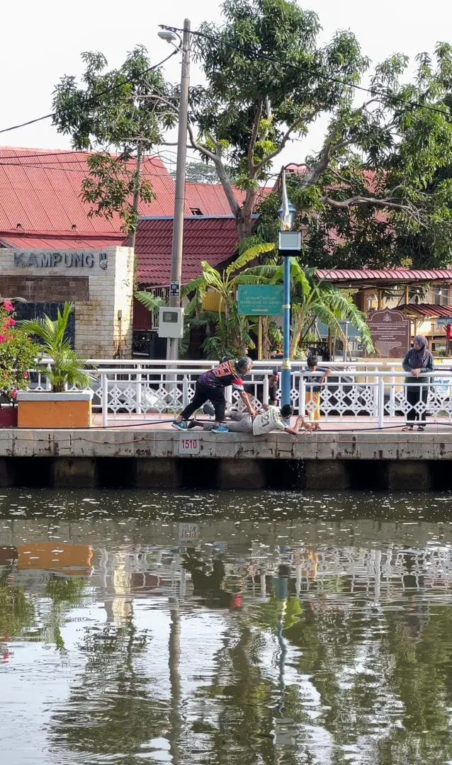 msian man helping to take out oyen from malacca river