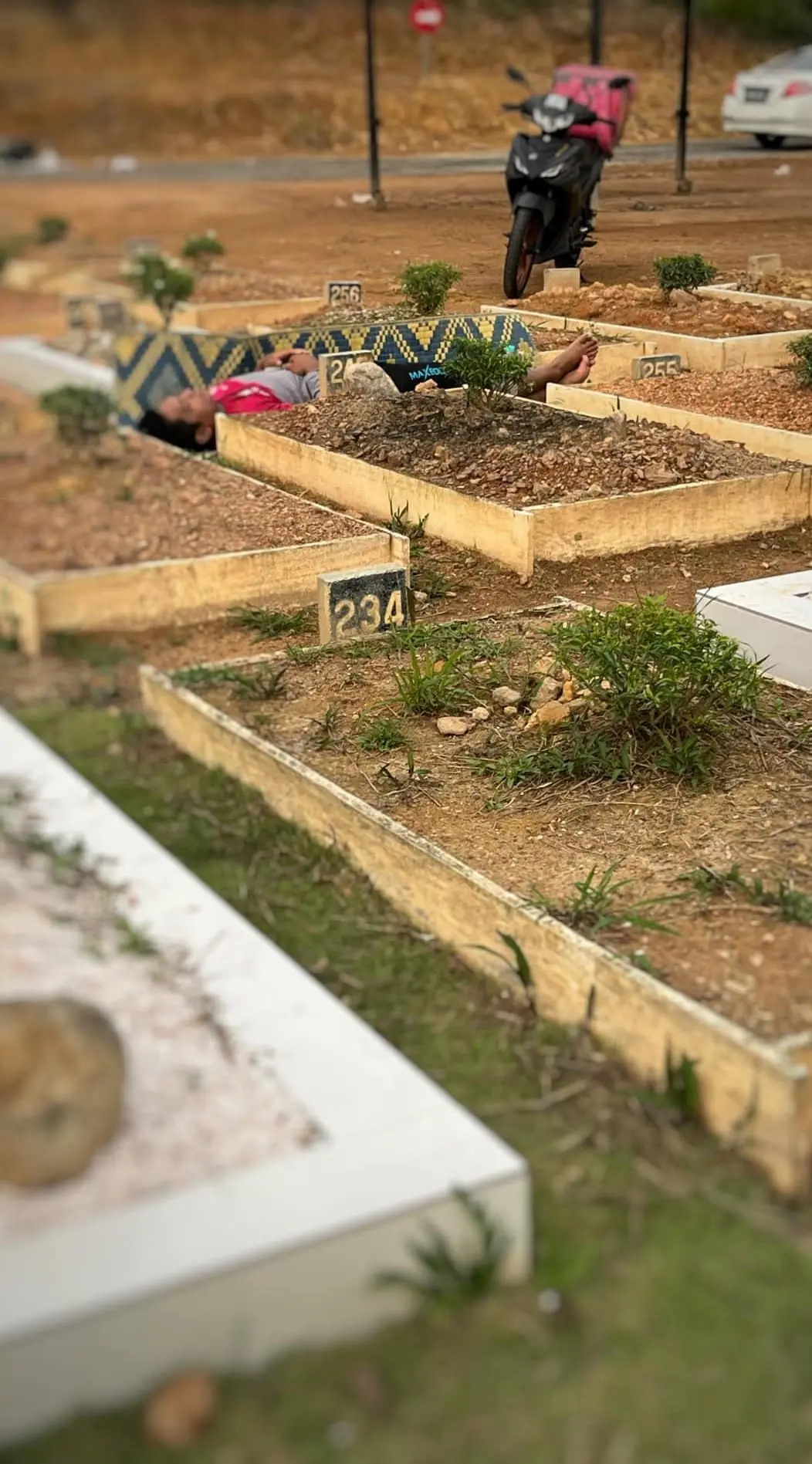 M'sian man lies beside mum's grave