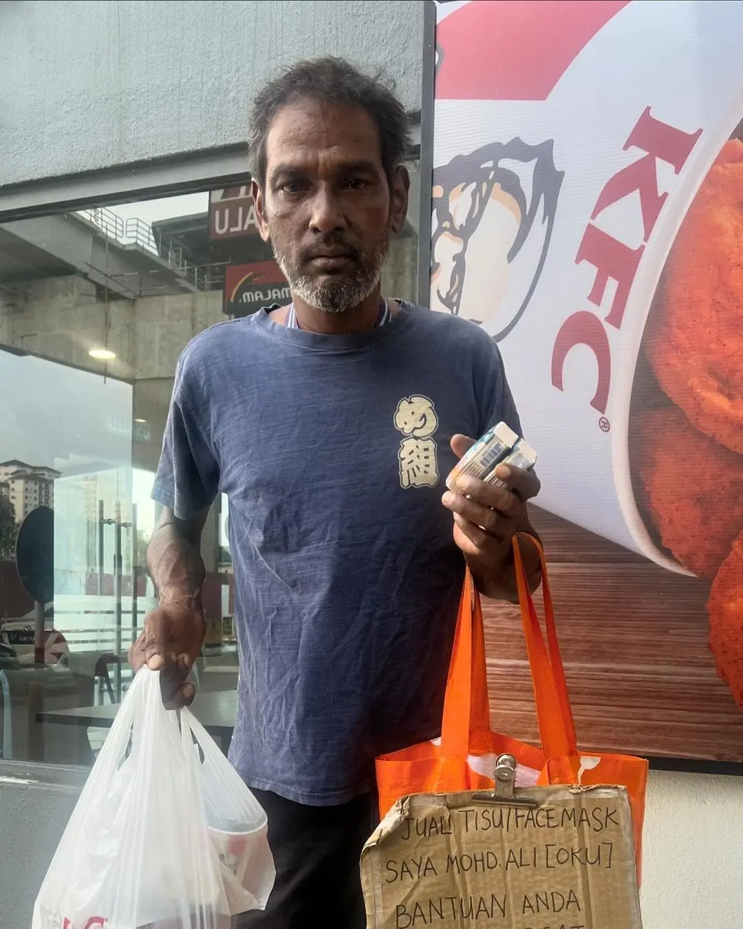 msian man selling tissue paper at petrol station