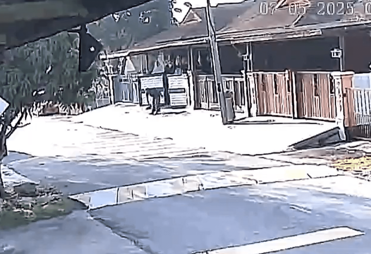 M'sian man sweeping front porch