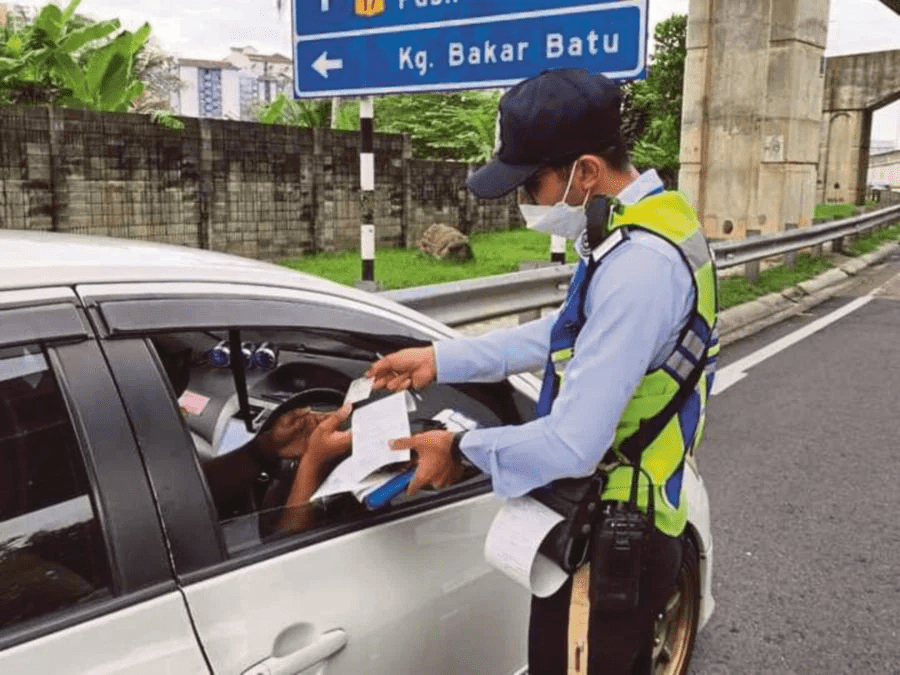 M'sian traffic police handing fine to a driver