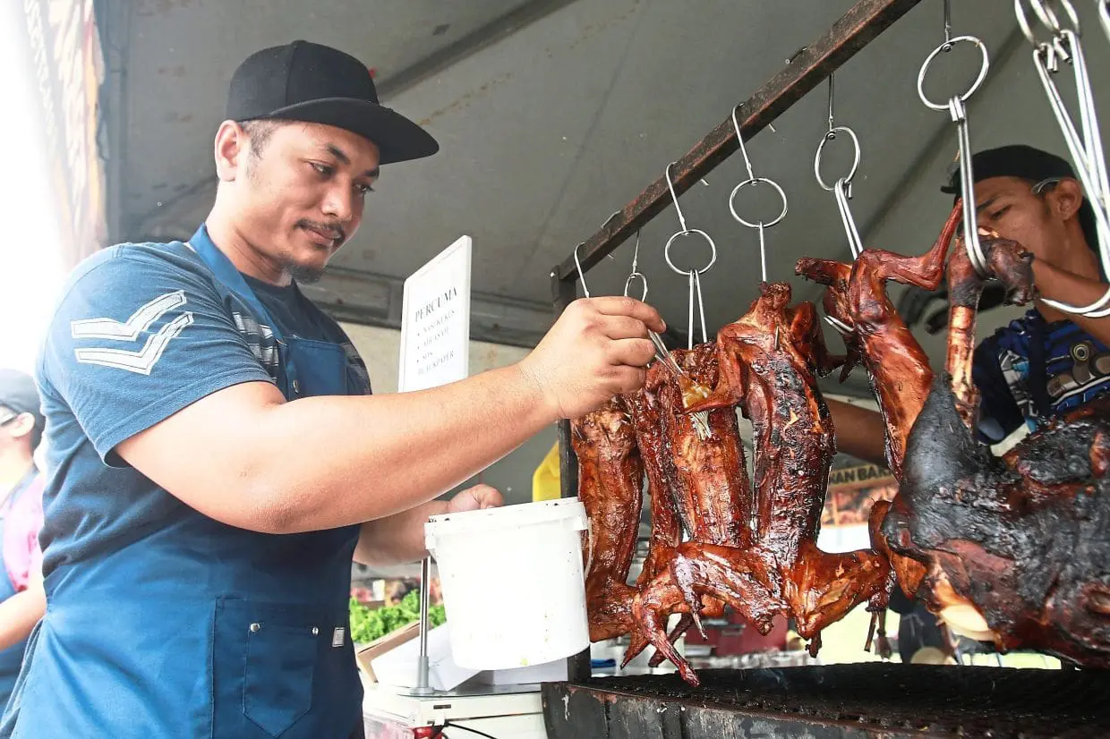 msian vendor applying butter on rabbot meat at his stall