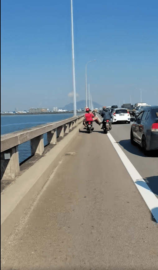 msian woman kicking other motor riders at Penang