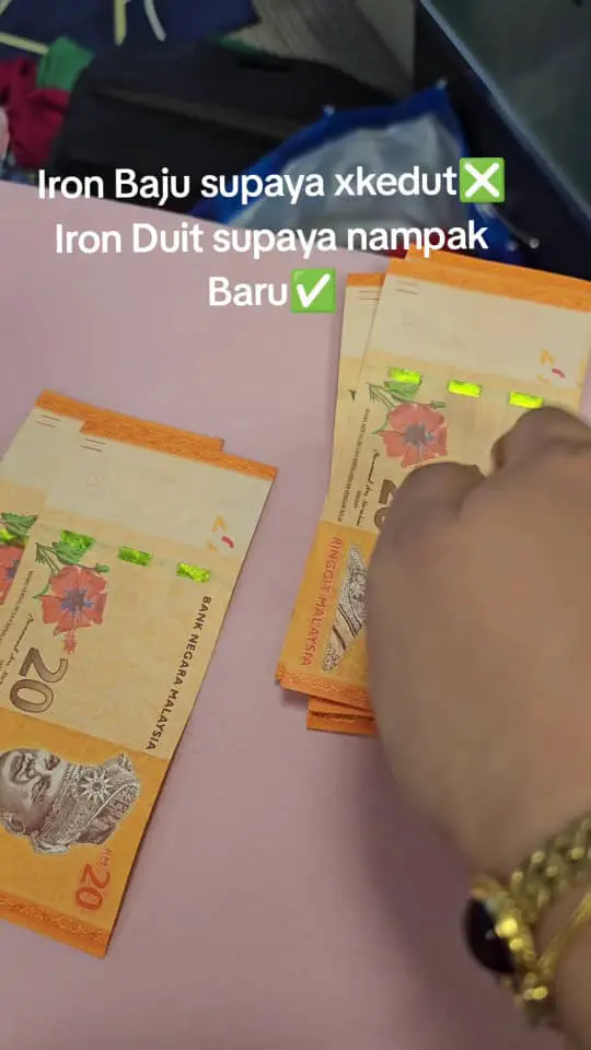 msian woman showing rm20 notes