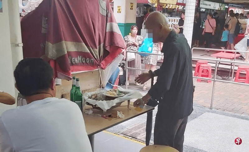 Old man in SG eating leftovers at food court