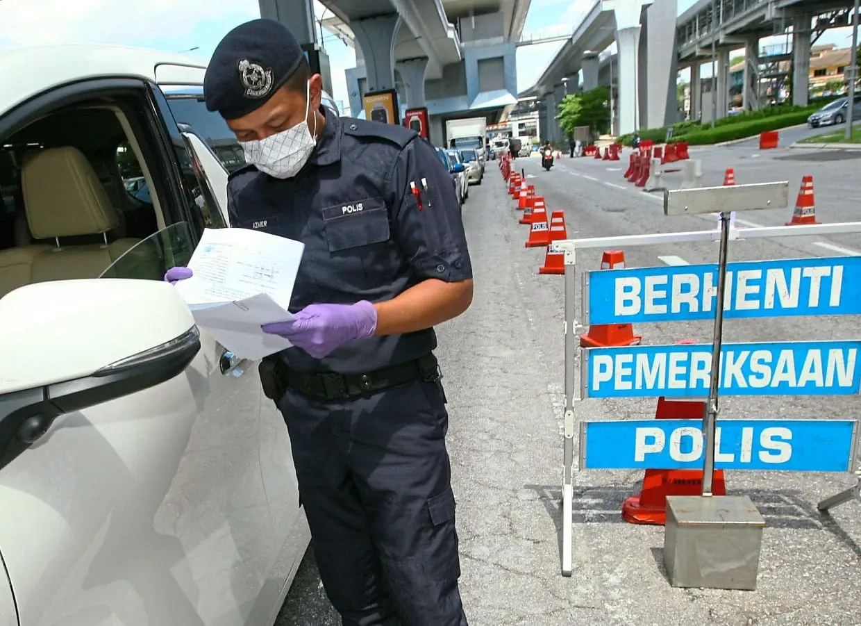 PDRM officer conducting checks at a roadblock