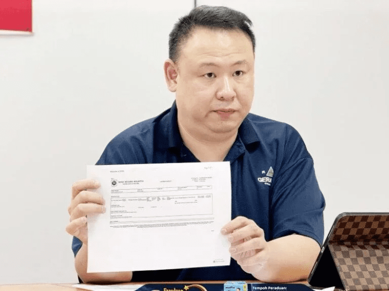 Penang Gerakan public complaints bureau chief Andrew Ooi shows police report