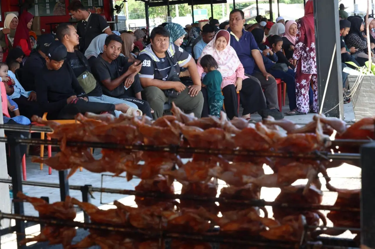 people waiting in queue for grilled chicken at bazaar ramadan