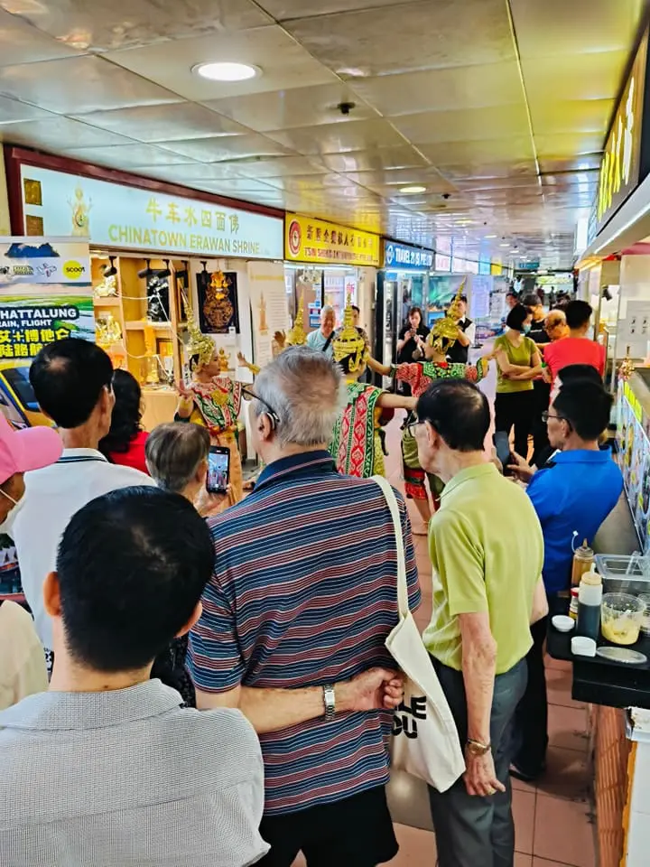People watching dance in front of Chinatown Erawan Shrine