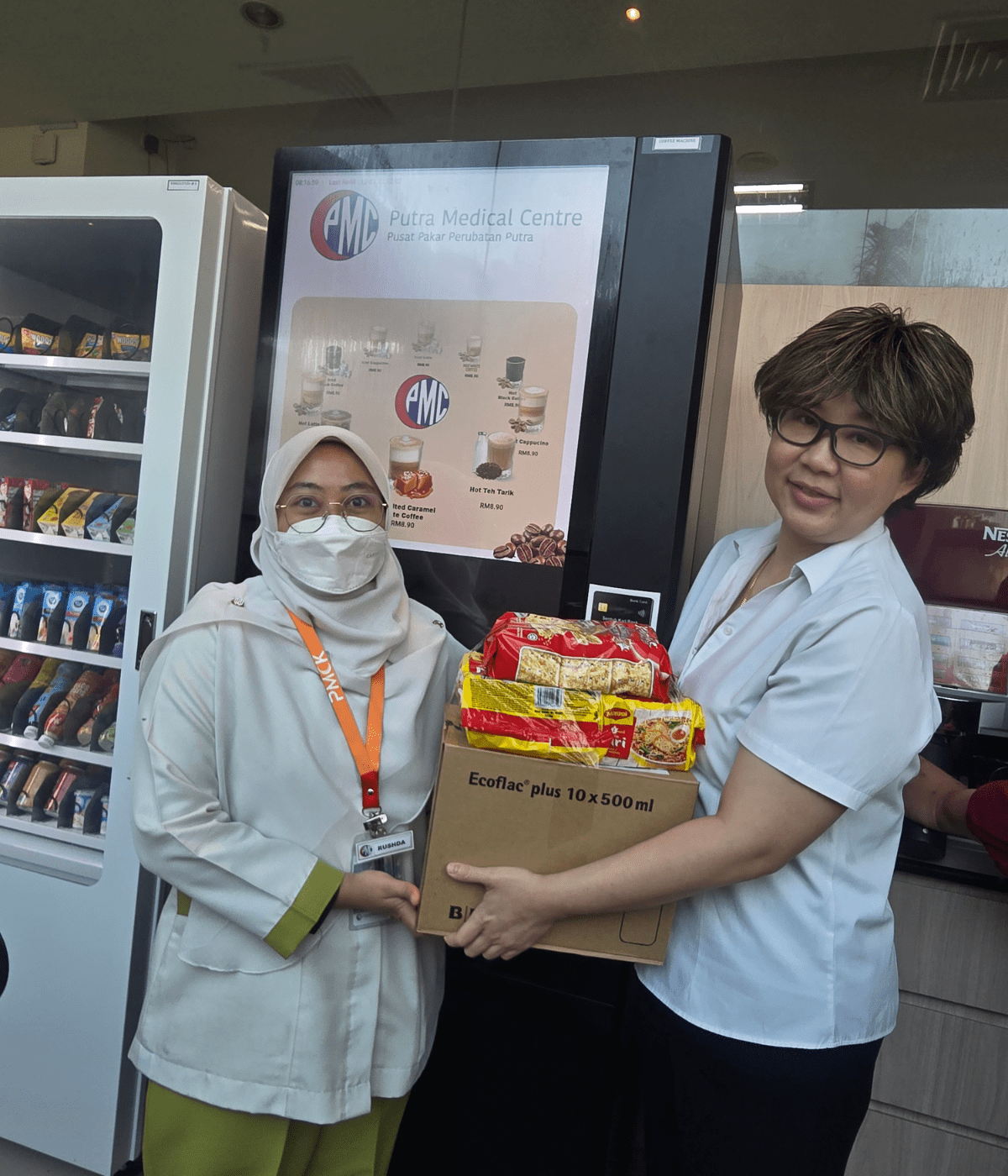 Photo 2 -  PMC's Director of Allied Health Services, Lee Geik Peng, offers a care package to a nurse at the hospital affected by Kedah's flood crisis.)