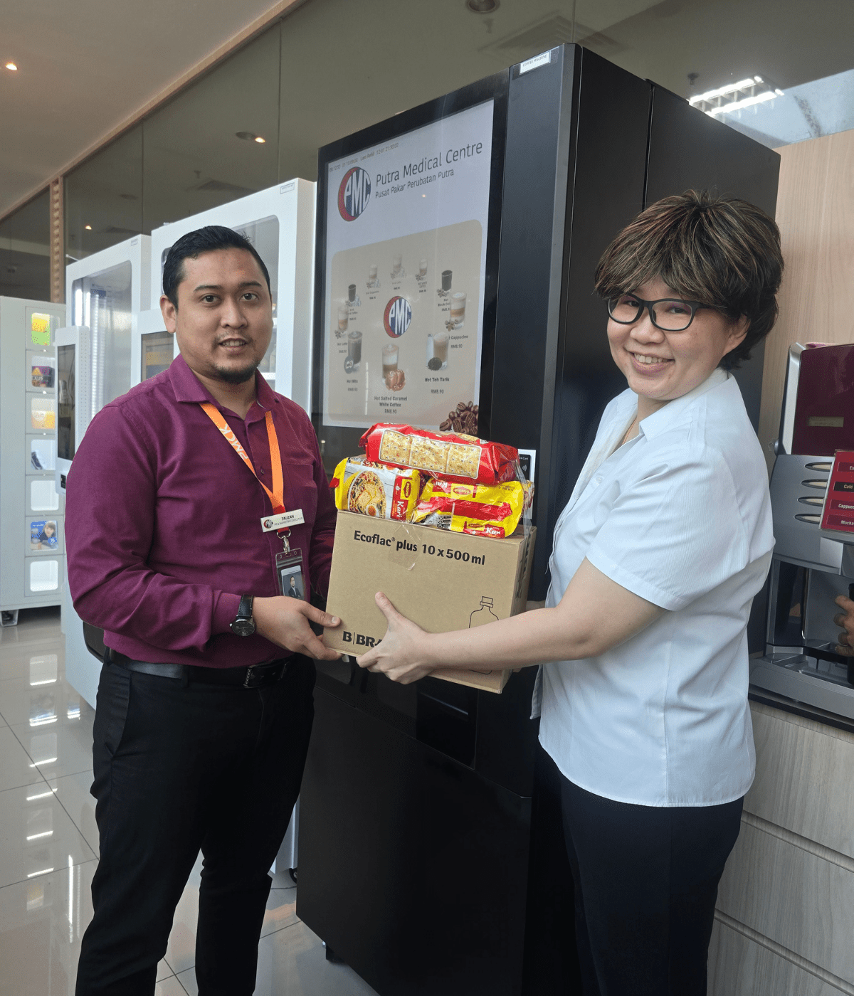 Photo 4 - Lee Geik Peng, PMC's Director of Allied Health Services, reaches out to a PR and Marketing executive of the hospital with a care package.