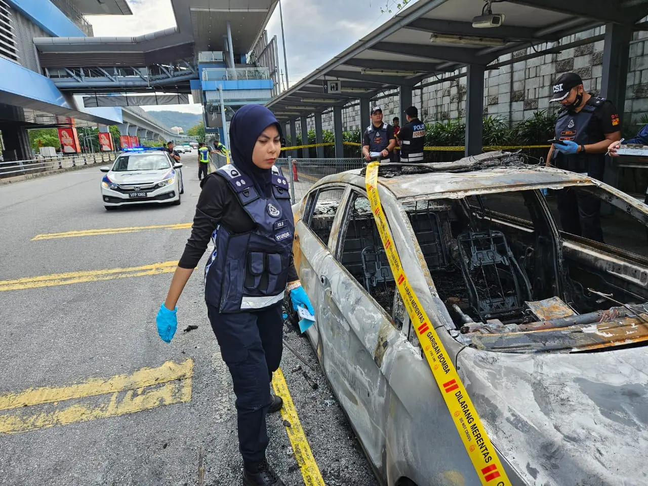 police woman checking the burnt car