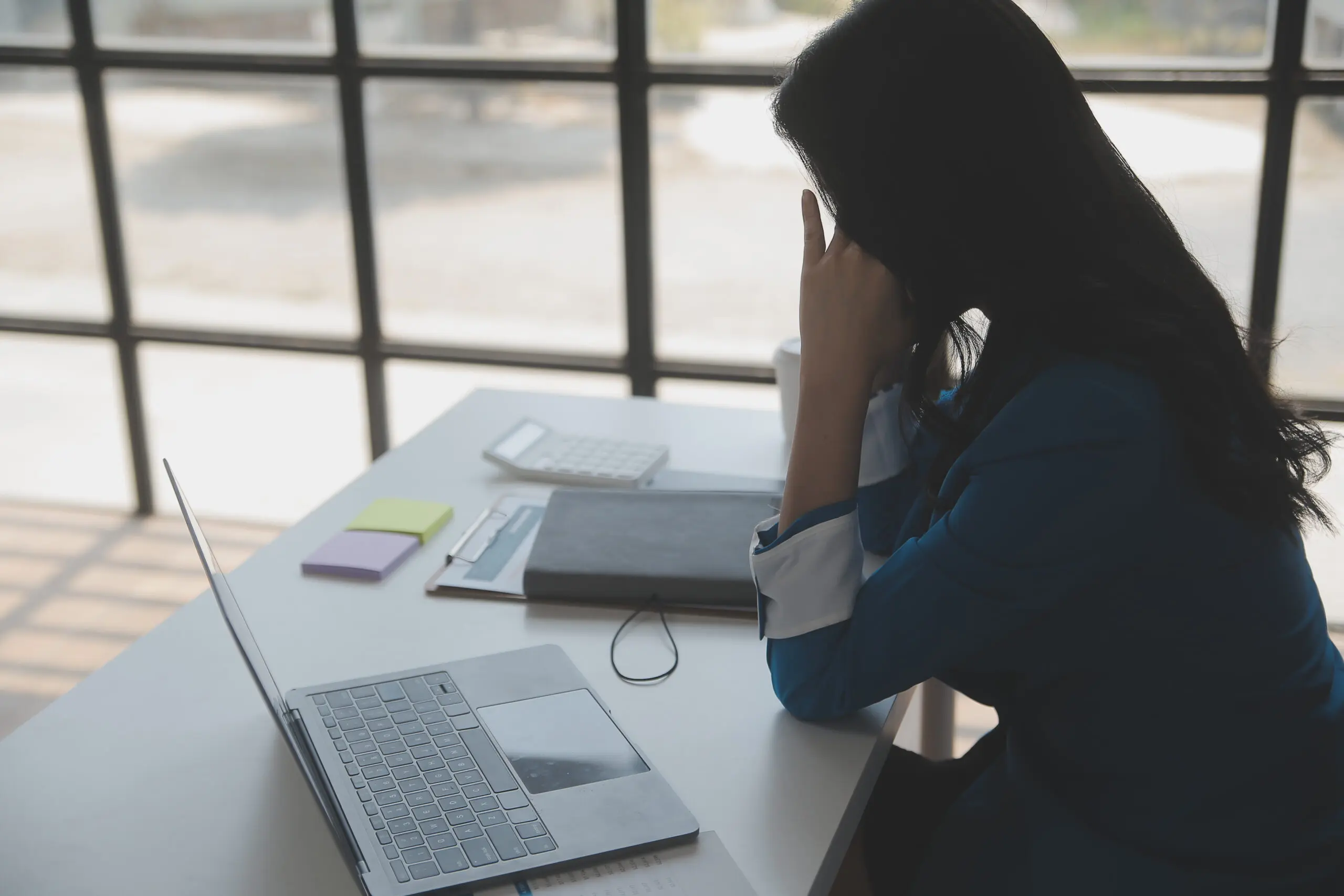 Frustrated woman sitting at her office desk.