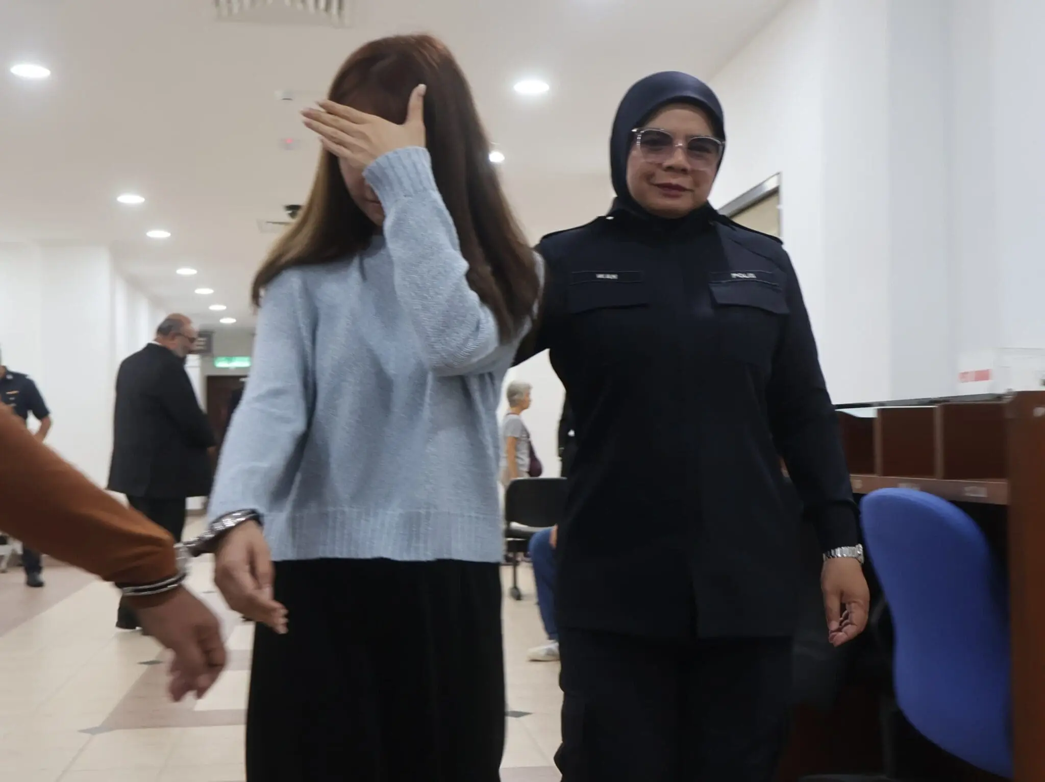 Sarah Leo hiding face from reporters in court