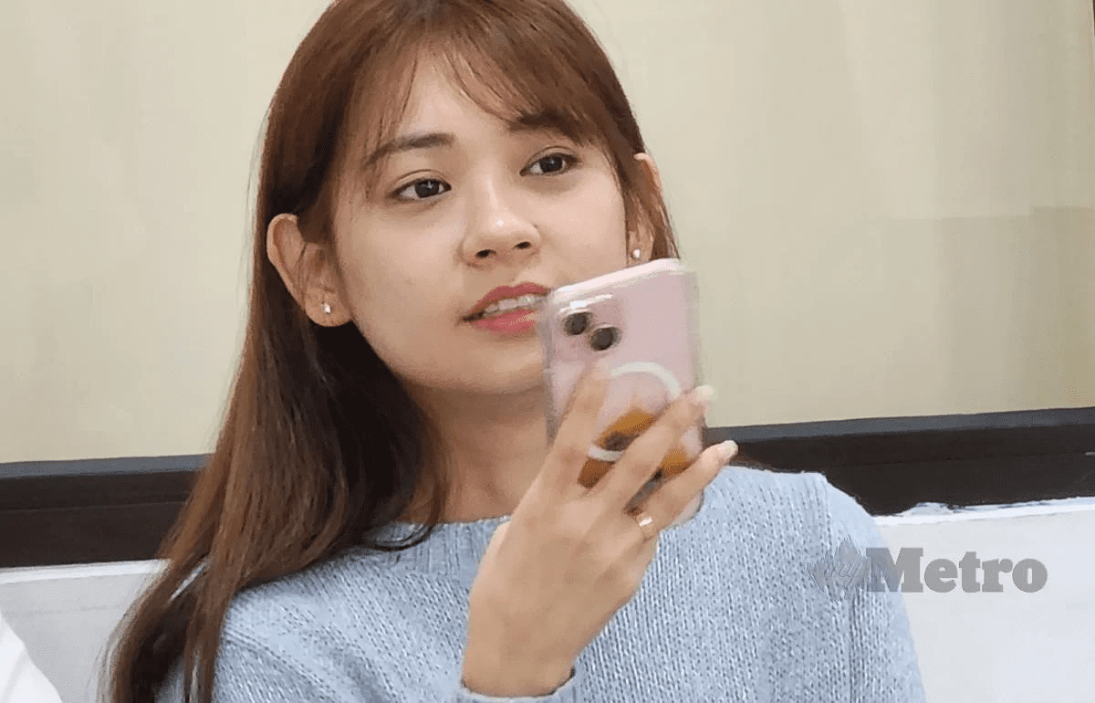 Sarah Leo holding her handphone