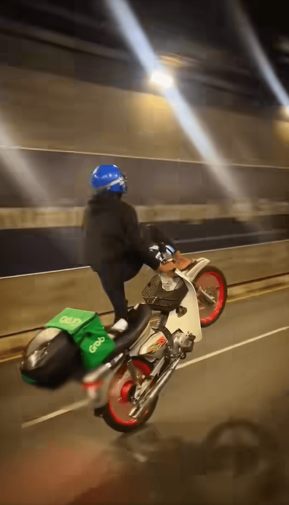 delivery rider doing wheelie stunt with his motorbike