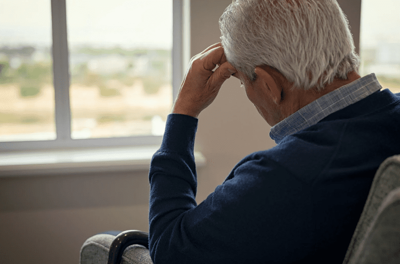 old man looking stressed sitting on a couch