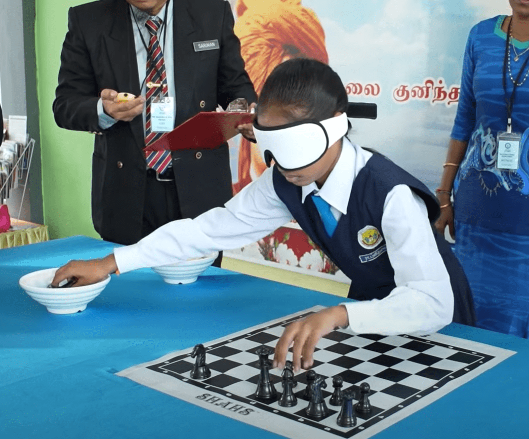Punithamalar Rajashekar arranging the chess pieces with blinded folded