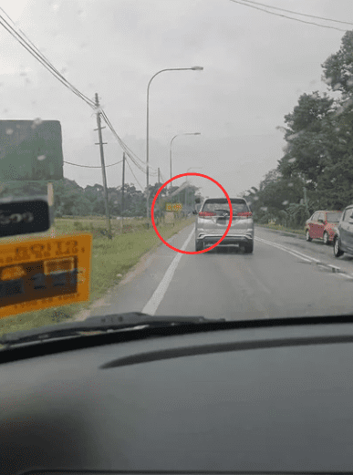 Young M'sian boy protruding out from car window