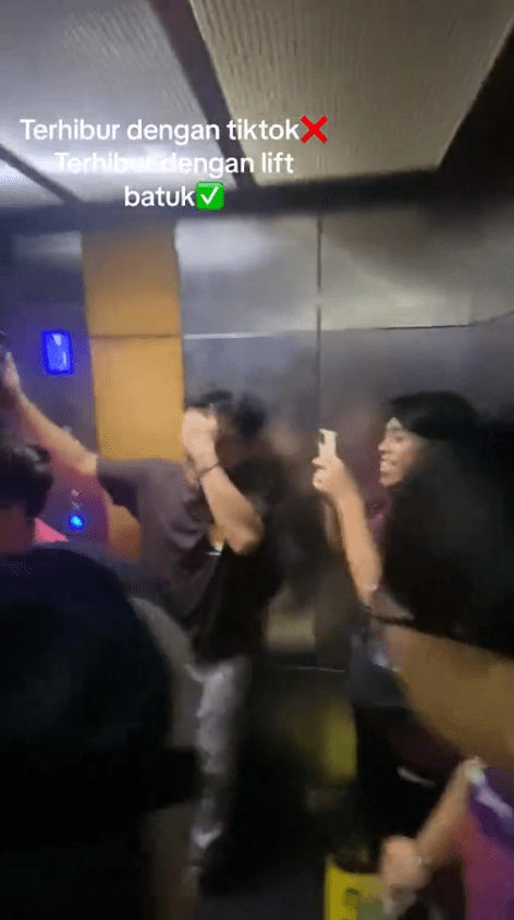 M'sian students recording the moment when the lift made its coughing sound.