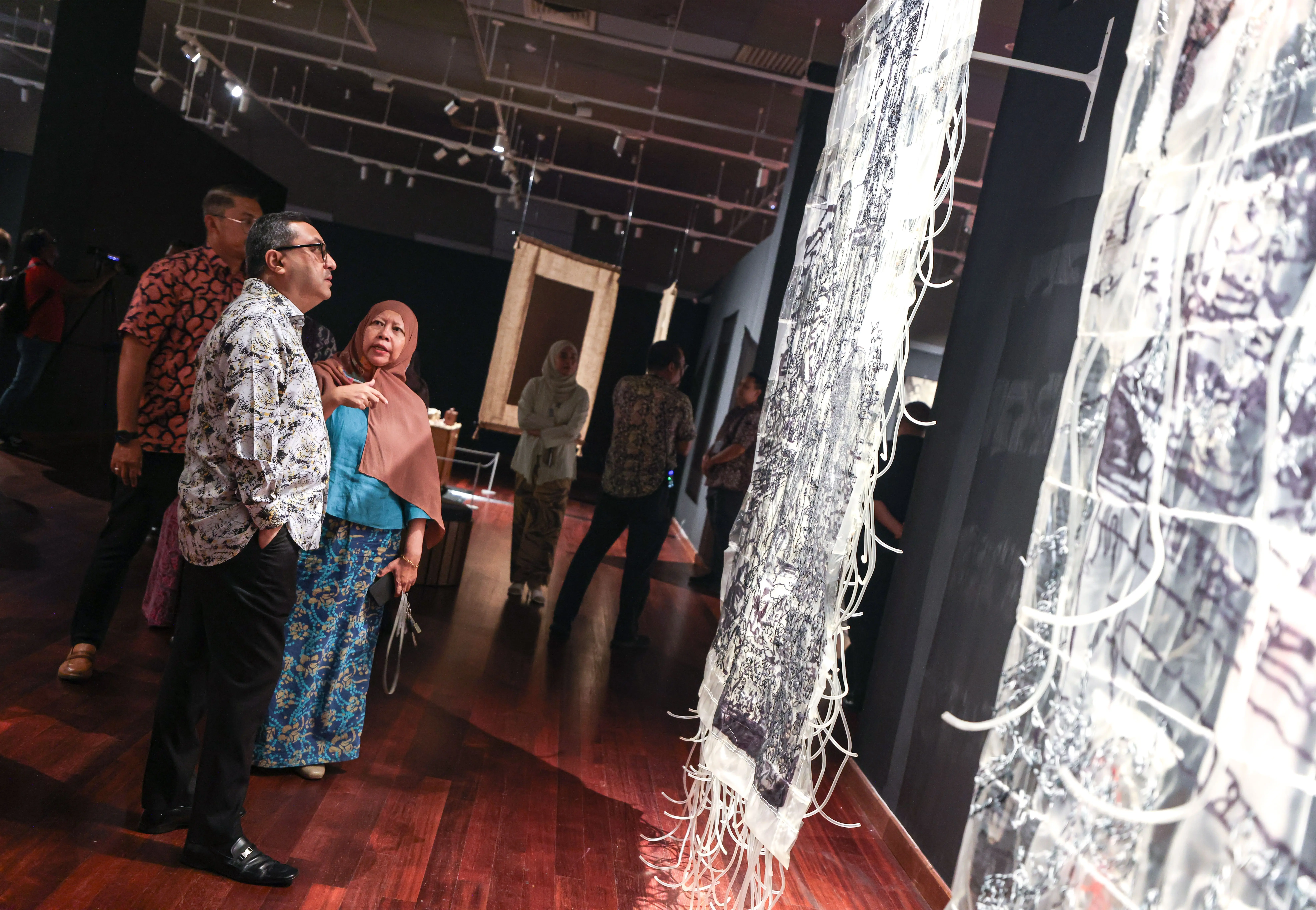 senior-curator-of-the-national-art-gallery-explaining-the-artwork-memory-of-life-by-thai-artist-nordiana-beehing-to-lpsvn-chairman-during-a-visit-to-the-imt-gt-rantau-exhibition